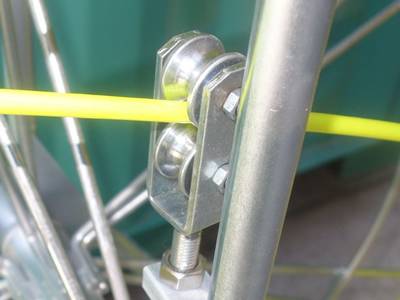 The rod guide of the duct rodder, with a yellow rod through it.